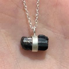 This listing is for one Dainty Black Tourmaline Chunk Necklace. This pendant comes on an adjustable chain that can be worn from 16-22 inches. Black Tourmaline is an opaque stone that is black in hue. It is typically found with vertical striations within the formation. This stone is never transparent or translucent unlike other forms of Tourmaline. Black Tourmaline is also known as Schorl. Black Tourmaline is electrical in nature and it provides a connection between Earth and spirit. It helps one to disconnect from obsessive behaviors. This stone doesn't absorb negative energy, rather transmutes it, therefore, Black Tourmaline represents Connectivity and Transmutation. Root Chakra: The Root Chakra bring security and grounding to everyday life. when this Chakra is balanced it can bring passi Silver Tourmaline Jewelry Gift, Adjustable Silver Tourmaline Jewelry, Silver Tourmaline Adjustable Jewelry, Spiritual Tourmaline Silver Jewelry, Spiritual Silver Tourmaline Jewelry, Black Tourmaline Meaning, Black Tourmaline Stone, Raw Black Tourmaline, Black Tourmaline Crystal