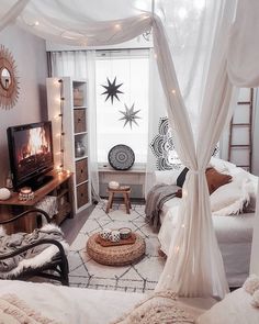 a bedroom with white curtains and lights on the ceiling