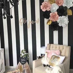 a baby's room decorated in black and white stripes with flowers on the wall