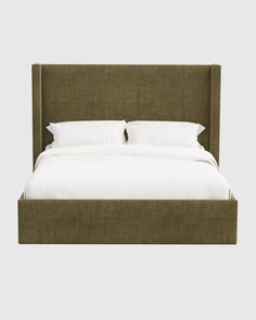 a bed with white pillows and green headboard