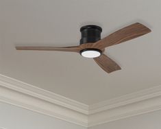 a ceiling fan mounted to the ceiling in a room with white walls and wood trim