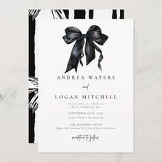 an elegant black and white wedding card with a bow on the front, featuring zebra stripes