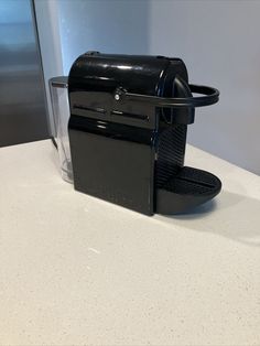 a black coffee maker sitting on top of a counter