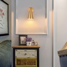 a lamp that is sitting on top of a table next to a dresser with drawers