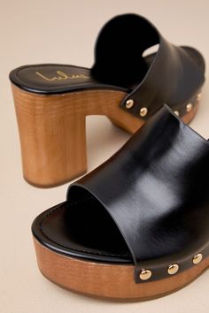 The Lulus Jaylani Black Platform Mule Sandals are the perfect combination of cute and cool for all your warm weather 'fits! Smooth faux leather shapes these essential sandals that have an almond footbed and a wide vamp strap with shiny gold stud accents along the side, all atop a 1.25"" toe platform. Easy slide-on design makes for effortless, everyday styling, while a sturdy wood-look block heel completes the classic clog-inspired look! 3. 75" wood-look block heel. Lightly cushioned insole. Rubb Chic Clogs With Ankle Strap And Removable Insole, Chic Ankle Strap Clogs With Removable Insole, Chic Open Toe Clogs With Cushioned Footbed, Trendy Gold Leather Sandals, Chic Clogs With Cushioned Footbed And Block Heel, Chic Beach Clogs With Heel Strap, Chic Open Toe Clogs For Vacation, Chic Summer Clogs With Buckle Closure, Elegant Open Toe Clogs For Summer