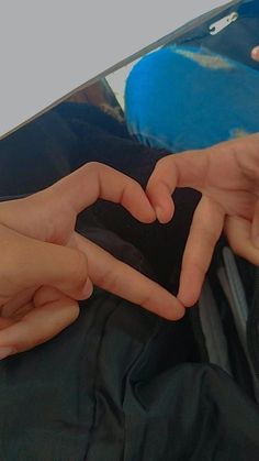 two hands making a heart shape with their fingers