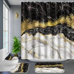 a bathroom with a shower curtain and rugs in black, gold and white colors