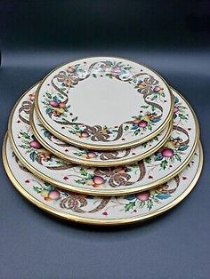 four white and gold plates with floral designs