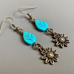 "Sunflower Earrings - Brass plated Sunflowers dangle from Turquoise Czech Glass Leaf Beads and Twisted Antiqued Brass plated Rings. Antiqued Brass Earwires Earrings measure j2.25\" from top of earwire to bottom of flowers." Vintage Flower Charm Dangle Earrings, Vintage Dangle Earrings With Flower Charm, Nature-inspired Drop Flower Earrings For Pierced Ears, Nature-inspired Dangle Flower Earrings, Nature-inspired Hypoallergenic Flower Dangle Earrings, Adjustable Flower-shaped Nature-inspired Earrings, Nature-inspired Adjustable Flower Earrings, Nature-inspired Hypoallergenic Flower Drop Earrings, Turquoise Dangle Earrings With Flower Charm