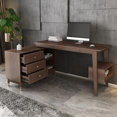 an office desk with drawers and a computer monitor on it, in front of a concrete wall