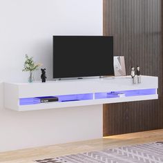 a flat screen tv sitting on top of a white shelf