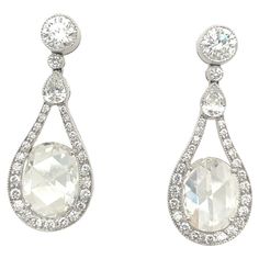 A beautifully designed pair of platinum and diamond drop earrings. The earrings are set with 2.89 carat oval rose cut diamonds. The mandolin style frame setting has .23 carats pear shaped diamonds, and .90 carats round diamonds. The combination of the 2 different diamond cuts catch the light just perfectly. The post back earrings measure 1.25" x .50". Stamped PLAT Luxury Vintage Single Cut Diamond Earrings, Luxury Fine Jewelry Chandelier Earrings With Prong Setting, Luxury Gia Certified Oval Diamond Earrings, Formal Pear-shaped Diamond Earrings With Single Cut Diamonds, Elegant Gia Certified Oval Diamond Earrings, Exquisite Oval Brilliant Cut Diamond Earrings, Diamond White Oval Diamond Earrings In Platinum, Exquisite Oval Diamond Earrings With Brilliant Cut, Platinum Diamond White Oval Diamond Earrings