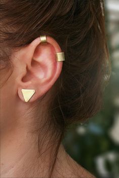 These ear cuff earrings are the perfect accessory for those who love to decorate their ears but don't want to commit to a piercing. You can choose between gold brass or silver 925, both of which are durable alloys that will last a long time. The earrings are expertly hand-cut, textured, and polished to give you a flawless finish. The helix ear cuff creates a convincing fake piercing effect, so you can enjoy the look without the commitment. Please note that the set does not include triangle stud Ear Wraps, Gold Cartilage Earrings, Helix Ear, Triangle Earrings Stud, Wrap Earrings, Fake Piercing, Gold Ear Cuff, Ear Cuff Earings, Ear Cuffs