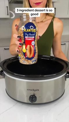 a woman holding a bottle of planters oil in front of an electric pressure cooker