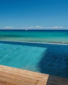 an empty swimming pool in front of the ocean