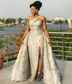 a woman in a white gown standing on a balcony