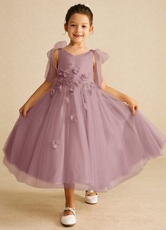 Minia is a charming flower girl matte satin A-line dress that features delicate tulle fabric that creates a whimsical, fun, and flowy effect. Her V-neckline is adorned with bow details on the shoulders that add an extra touch of sweetness and charm. The full A-line silhouette ensures a graceful and twirl-worthy appearance. Satin Flower Girl Dresses, Tea Length Flower Girl Dress, Satin Flower Girl Dress, Dress Flower, Matte Satin, Tulle Fabric, Tea Length, Girl Dresses, Flower Dresses