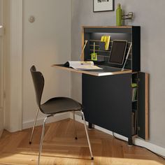 a desk with a laptop on top of it and a chair in front of it