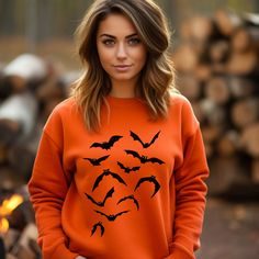 Elevate your Halloween wardrobe this spooky season with our exclusive **Halloween Bats Sweatshirt**. If you're a fan of all things eerie and embrace the spirit of the season with enthusiasm, this sweatshirt is an absolute must-have. Our **Spooky Season Halloween Bats** sweatshirt perfectly captures the essence of Halloween, featuring a playful and slightly mischievous bat design. The bats soar across the fabric, adding a touch of whimsy to your spooky ensemble. In vibrant orange, this sweatshirt not only complements the Halloween color palette but also adds a pop of fun to your fall wardrobe. Whether you're attending a haunted house event, trick-or-treating with friends and family, or just looking to get into the Halloween spirit, our sweatshirt sets the tone with style. But that's not all Horror Style Crew Neck Sweatshirt For Fall, Horror Crew Neck Sweatshirt For Fall, Horror Long Sleeve Sweatshirt For Halloween, Fall Horror Crew Neck Sweatshirt, Spooky Halloween Crew Neck Sweater, Fall Costume Party Crew Neck Top, Crew Neck Tops For Costume Party In Fall, Fall Crew Neck Top For Costume Party, Halloween Graphic Print Sweatshirt