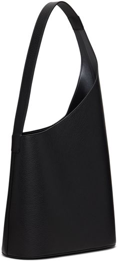 Grained calfskin tote in black. · Integrated shoulder strap · Logo graphic embossed at face · Magnetic closure · Patch pocket at interior · Grained faux-leather lining · H22.5 x W11.75 x D5.5 Supplier color: Grain Black Modern Black Textured Leather Shoulder Bag, Sleek Calf Leather Shoulder Bag For Everyday Use, Everyday Black Calf Leather Shoulder Bag, Black Calf Leather Shoulder Bag For Everyday, Black Calf Leather Shoulder Bag With Smooth Grain, Modern Black Shoulder Bag With Leather Backing, Designer Black Shoulder Bag With Smooth Grain, Black Textured Leather Structured Shoulder Bag, Modern Leather-backed Shoulder Bag For Evening