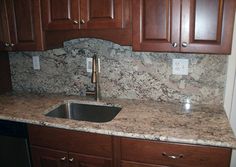 a granite counter top in a kitchen with wooden cabinets