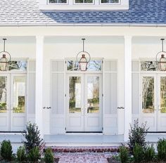 a white house with two double doors and brick walkway leading to the front door area