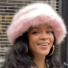 a woman wearing a pink hat while walking down the street