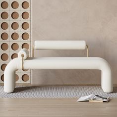 a white couch sitting on top of a hard wood floor next to a book shelf