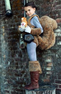 a woman dressed as a teddy bear sitting on a brick wall