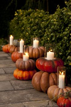 pumpkins and candles are lined up on the ground