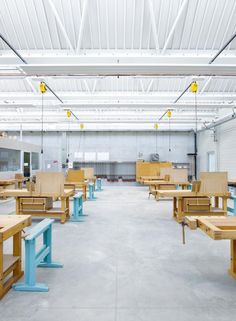 an empty warehouse with wooden benches and tables