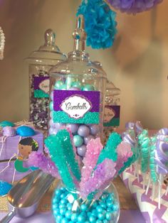 a table topped with candy and candies under a glass jar filled with gumballs