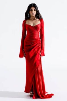 a woman in a red dress is posing for the camera with her hands on her hips