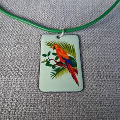 Beautiful parrot with 18 inch leather cord. The pendant is 2 inches long and 1 5/16 wide. Green and oranges are the main colors. Parrot Green Necklace, Parrot Necklace, Enameled Jewelry, Purple Wisteria, Bird Pendant, Enamel Jewelry, Phoenix Az, Flower Pendant, Main Colors