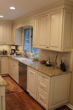 a kitchen with white cabinets and granite counter tops