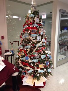 a decorated christmas tree in an office cubicle with red and white ribbons on it