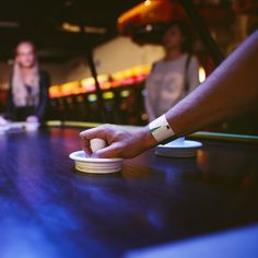 two people standing at a table and one person is reaching for something on the plate