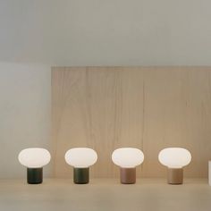 four different colored lamps sitting on top of a table