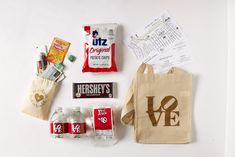 the contents of a bag laid out on top of a white surface with paper and other items