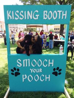 a couple of people that are hugging each other in front of a booth with dogs on it