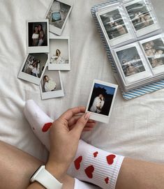 a person laying on a bed with some pictures and hearts painted on their leg socks