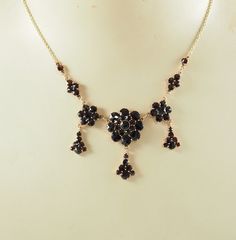 A beautiful Art Deco period Bohemian garnet and 8K yellow gold festoon necklace, 333 standard gold. The garnets of a dark cherry red hue.  The central cluster with a central rose cut garnet, 4mm in diameter, and mille grain set, with a surround of 8 circular rose cut garnets, each 3mm in diameter, with a further outer ring of garnets each 5mm in diameter, with a triangular drop of 7 rose cut garnets.  Flanked by two clusters, each 1.1cm in diameter, with a central garnet 4mm in diameter with a s Garnet Necklace Vintage, Elegant Yellow Gold Garnet Necklace, Elegant Garnet Necklace With Faceted Beads, Vintage Multi-stone Garnet Jewelry, Red Garnet Faceted Necklace, Festoon Necklace, Art Deco Period, Wedding Jewellery Necklace, Wedding Necklace