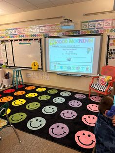 a classroom with lots of smiley faces on the floor and a projector screen in the corner