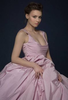 a woman in a pink dress sitting down