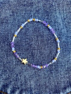 This bracelet is celestial. It belongs in the galaxy. It is a beautiful seed bead bracelet made up of blue, gold, & white seed beads. The pop of color are the purple crystal beads and the long silver "mirrored" beads. The bracelet is stretchy and comes in many different sizes, even for your little one! The star is gold plated and will last with care. Diy Trinkets, Star Seed, Bracelet Star, Bracelet Layering, Bracelet Stacking, Clay Stuff, Purple Bracelet, Necklace Ideas, Seed Bead Bracelet