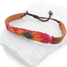 Hand embroidered bracelet with cotton thread in shades of orange, green, red and copper-colored metallic thread, on a pink and brown vinyl with ribbon. Adjustable brown cord clasp.Length: Adjustable (from 6.29 inch. to 8.46 inch.)Width: 0.59 inch. approximately Embroidered Bracelet, Ornament Storage, Colorful Bracelet, Textiles Techniques, Oval Plates, Pink And Brown, Facial Mist, Green And Red, Colorful Bracelets