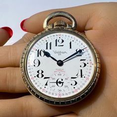 a person holding an antique pocket watch in their hand