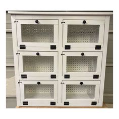 a white cabinet with six drawers and four shelves on each side that has holes in the bottom