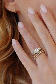 a close up of a person's hand with two rings on their fingers and one ring in the middle