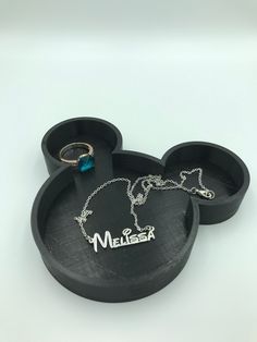 the mickey mouse earring and necklace are in black trays with name charms on them